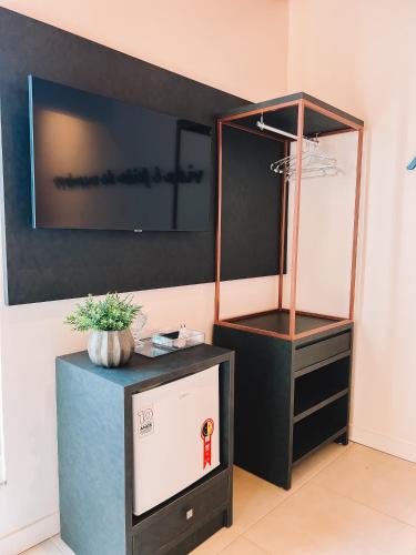 a room with a stand with a tv on a wall at Casa Cancun Hotel Boutique & Eventos in Penha