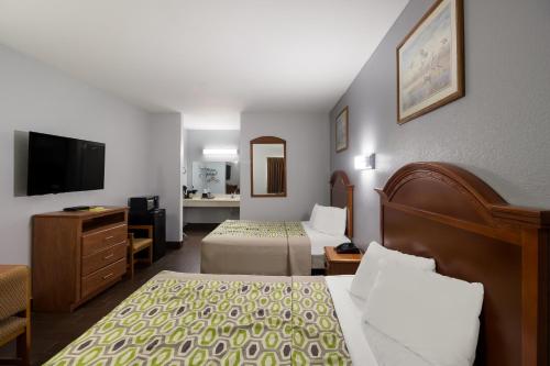 Habitación de hotel con 2 camas y TV de pantalla plana. en Scottish Inn & Suites, en Hankamer