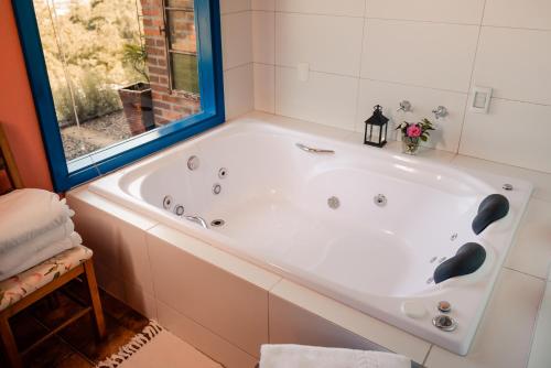 a white bath tub in a bathroom with a window at Pousada Morada Dos Anjos in Arroio do Meio