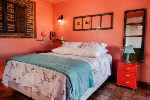 a bedroom with a bed and a red night stand at Pousada Morada Dos Anjos in Arroio do Meio