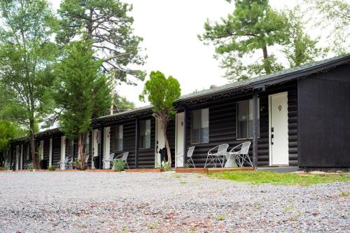 ein schwarzes Haus mit Stühlen draußen in der Unterkunft Corduroy Lodge in Pinetop-Lakeside