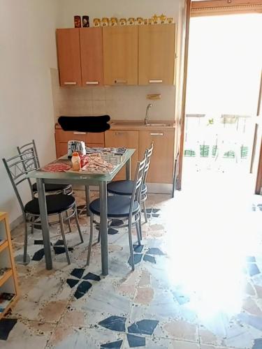 a kitchen with a table and chairs in a room at Quedar-se a l'Alguer in Alghero