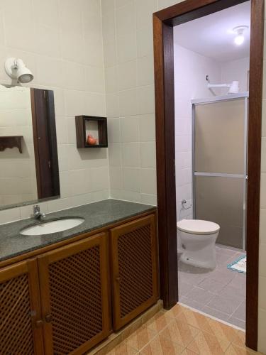 ein Bad mit einem Waschbecken und einem WC in der Unterkunft APARTAMENTO PRAIA DO MORRO, 04 QUARTOS, ATE 10 PESSOAS. in Guarapari