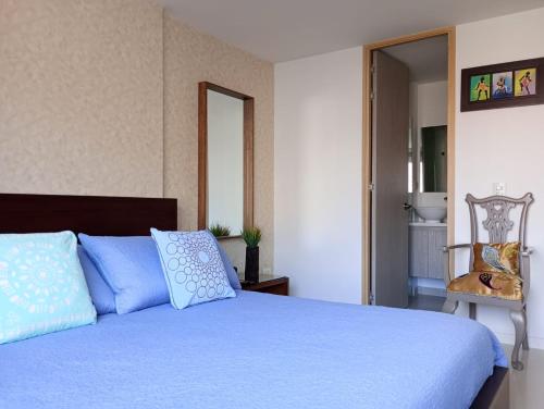 a bedroom with a blue bed and a chair at Ubicación privilegiada. Todo al alcance de tu mano in Sabaneta