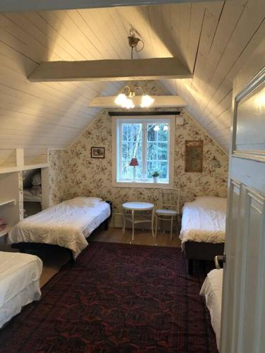a attic room with two beds and a window at Vacation in Wonderful environment! - Uppsala in Järlåsa