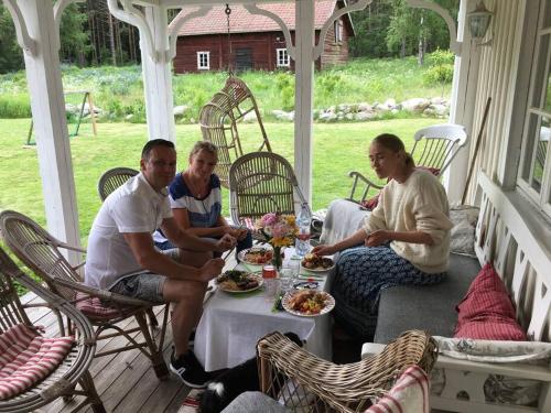 Un groupe de personnes assises autour d'une table sur une terrasse couverte dans l'établissement Vacation in Wonderful environment! - Uppsala, 