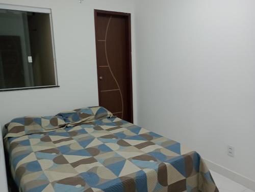 a bed in a room with a mirror at Casa em Jauá in Camaçari