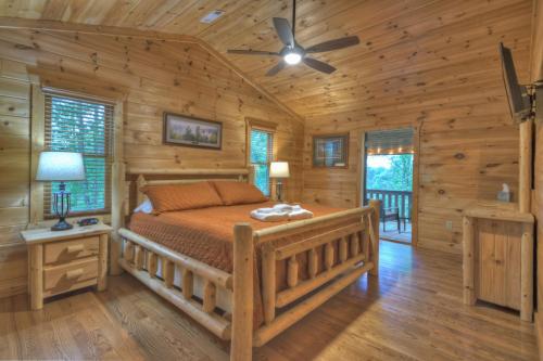 ein Schlafzimmer mit einem Bett in einem Blockhaus in der Unterkunft ESCAPE & ENJOY HAVEN - Cabin with Game Room & Hot Tub in Blue Ridge