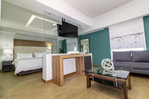 a hotel room with a bed and a couch at Holiday Inn Uruapan by IHG in Uruapan del Progreso
