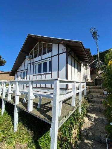 a house with a porch and stairs leading to it at Algarrobo Beach House Casa de Playa in Algarrobo