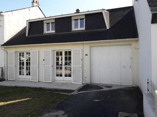 eine Garage mit weißen Türen und einem Haus in der Unterkunft chez LOLO in Saint-Nazaire