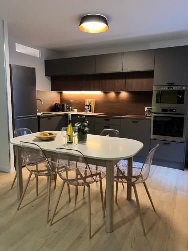 eine Küche mit einem weißen Tisch und Stühlen in der Unterkunft Le K Appartement - Strasbourg in Straßburg