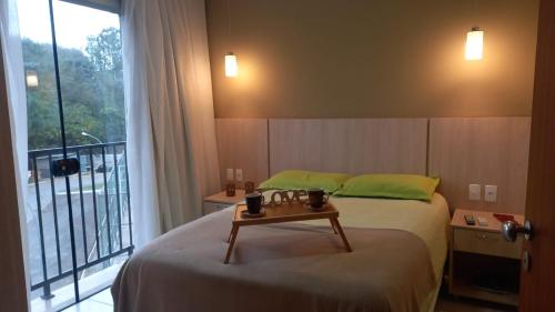 Un dormitorio con una cama con una mesa. en O Paraiso é aqui!, en Barra do Piraí