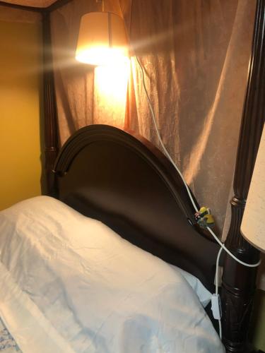 1 cama con cabecero negro y lámpara en Studio with private bath room, en Chicago