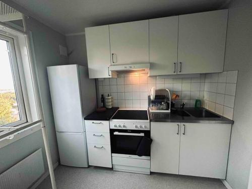 a kitchen with white cabinets and a white refrigerator at Appartement on budget in oslo! in Oslo