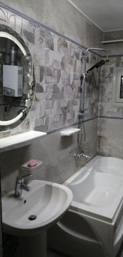 ein Badezimmer mit Waschbecken, Toilette und Spiegel in der Unterkunft Beautiful Old Apartment in Madinat Al Ashir min Ramadan