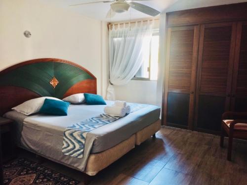 - une chambre avec un grand lit et des oreillers bleus dans l'établissement Flamingo Plus Ocean View, à Cancún