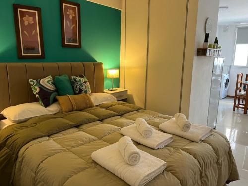 1 dormitorio con 1 cama grande y toallas. en Alvarado Apart en Bahía Blanca