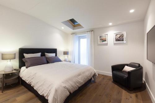 une chambre avec un lit, une chaise et une fenêtre dans l'établissement Duplex Nice Avenue Jean-Médecin, à Nice