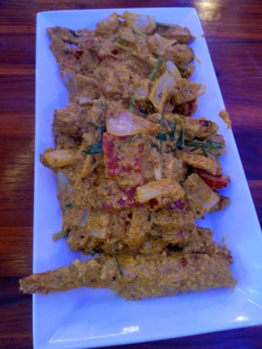 a white plate of food on a wooden table at Rainbow Hotel Vientiane in Vientiane