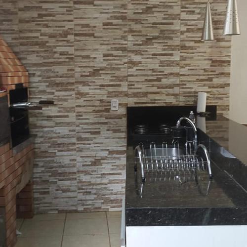 una cucina con bancone e muro di mattoni di Sobrado lindo a Campo Grande