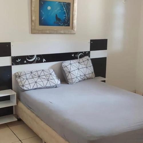1 cama en una habitación con una foto en la pared en Sobrado lindo en Campo Grande