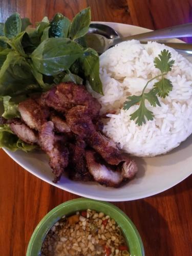 a plate of food with rice and meat and a salad at Rainbow Hotel Vientiane in Vientiane