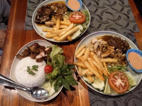 three bowls of food on a table with french fries at Rainbow Hotel Vientiane in Vientiane