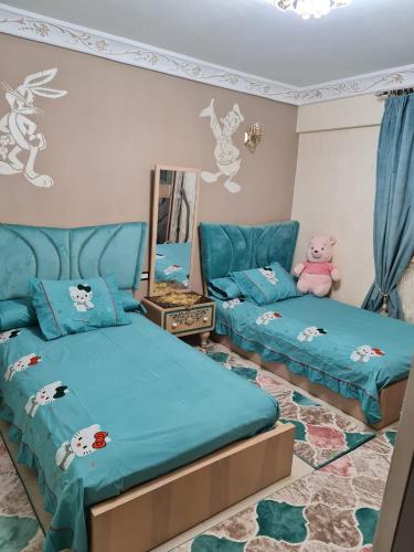 ein Kinderschlafzimmer mit 2 Betten und einem Spiegel in der Unterkunft Beautiful Old Apartment in Madinat Al Ashir min Ramadan