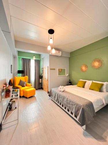 ein Schlafzimmer mit einem großen Bett und einem gelben Sofa in der Unterkunft Triple J hotel Trang in Trang