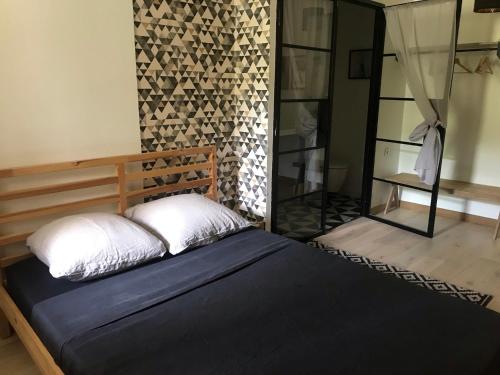 um quarto com uma cama num quarto com um espelho em Le Patio em Bordeaux