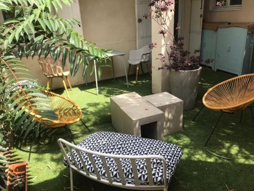un patio con sillas, mesa y plantas en Le Patio, en Burdeos