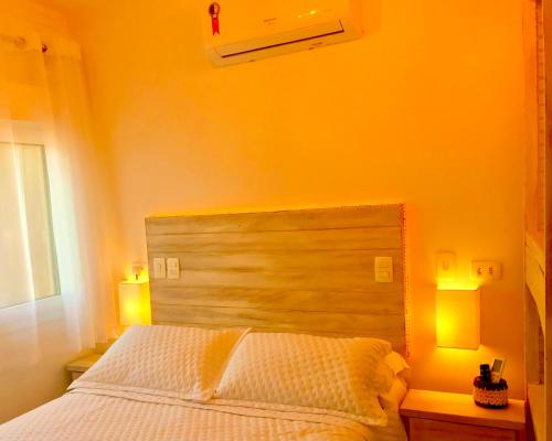 a bedroom with a bed with two lamps on tables at Petite Suite Juquehy - A 2 quadras do Mar - Pequena mas completa - 13 metros quadrados - Ar cond - Frigobar - Microondas - TV Smart - Serviço de Praia - Roupa cama e banho luxo - Wi Fi - Janelas e portas acústicas - Tudo Novo e cheiroso! in Juquei