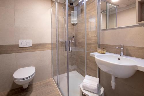 a bathroom with a shower and a sink and a toilet at Fantinello Hotel in Caorle