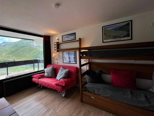 ein Schlafzimmer mit einem Etagenbett und einem roten Stuhl in der Unterkunft Studio Les Menuires, 1 pièce, 3 personnes - FR-1-452-281 in Les Menuires