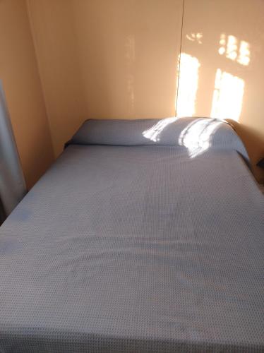 a large bed in a small room with a window at Cabañas deja vu in El Calafate