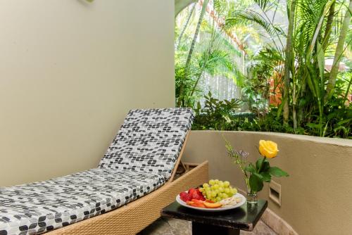 a chair sitting on a balcony with a bowl of fruit at Maya Villa Condo Hotel and Beachclub in Playa del Carmen