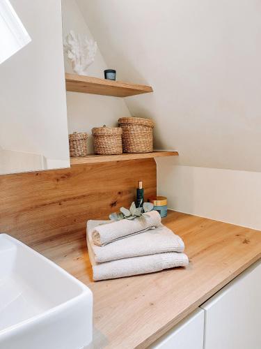 Cozy Guesthouse في بروج: حمام به مناشف بيضاء على كونتر خشبي