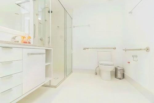 ein weißes Bad mit einem WC und einer Dusche in der Unterkunft Vintage Master - Praça Encol in Porto Alegre
