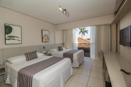 una camera d'albergo con due letti e una televisione di Pousada Molinha a Penha