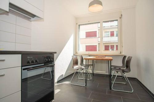 a kitchen with a table and chairs and a window at Modern 2-Bedroom Apartment in City Centre in Basel