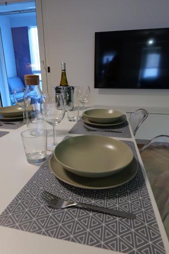 einen Tisch mit einer grünen Platte und Gläsern darauf in der Unterkunft Le K Appartement - Strasbourg in Straßburg