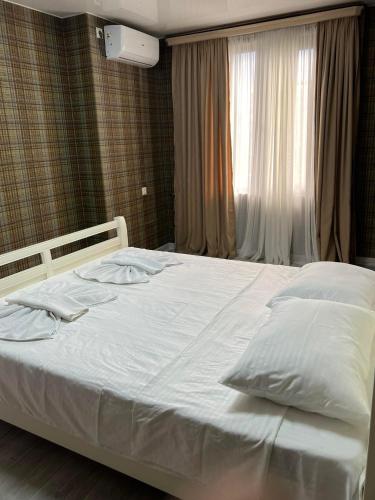 a bedroom with a large white bed with a window at Villa for families and friends 2 in Tbilisi City