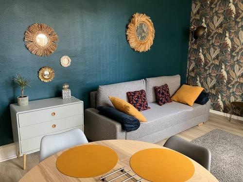 uma sala de estar com um sofá e uma mesa em Joli appartement à Brive la gaillarde em Brive-la-Gaillarde