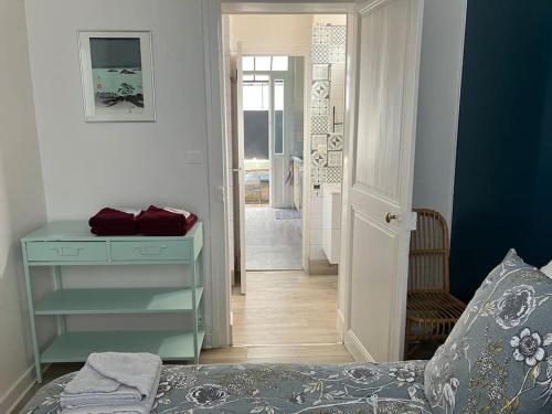 een slaapkamer met een bed en een dressoir en een hal bij Joli appartement à Brive la gaillarde in Brive-la-Gaillarde