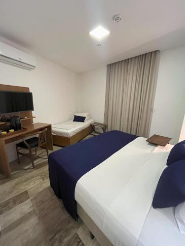 a hotel room with a large bed and a desk at Leblon Design Hotel in Rio de Janeiro