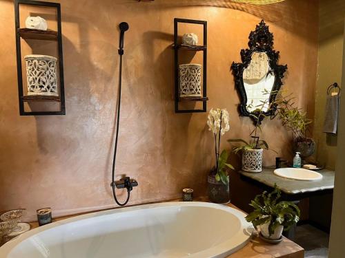 un bagno con una grande vasca e un lavandino di A Bird Cage Stay & Cottage a Haenertsburg