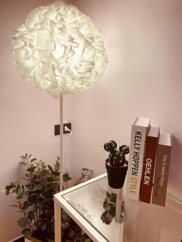 a white lamp on a table next to a plant at Triple J hotel Trang in Trang