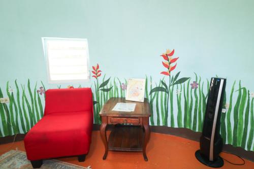 a living room with a red chair and a tv at La Casa de Vida Natural in Rio Grande