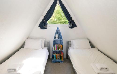 2 camas individuales en una habitación con ventana en Escape to a Clifftop Chalet with pool and tennis onsite - 38 Kingsdown Park, en Kingsdown
